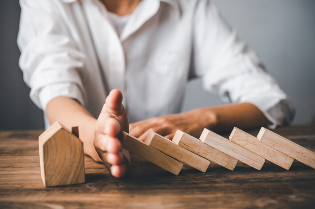 hand stopping risk the wooden blocks from falling on house, Home insurance