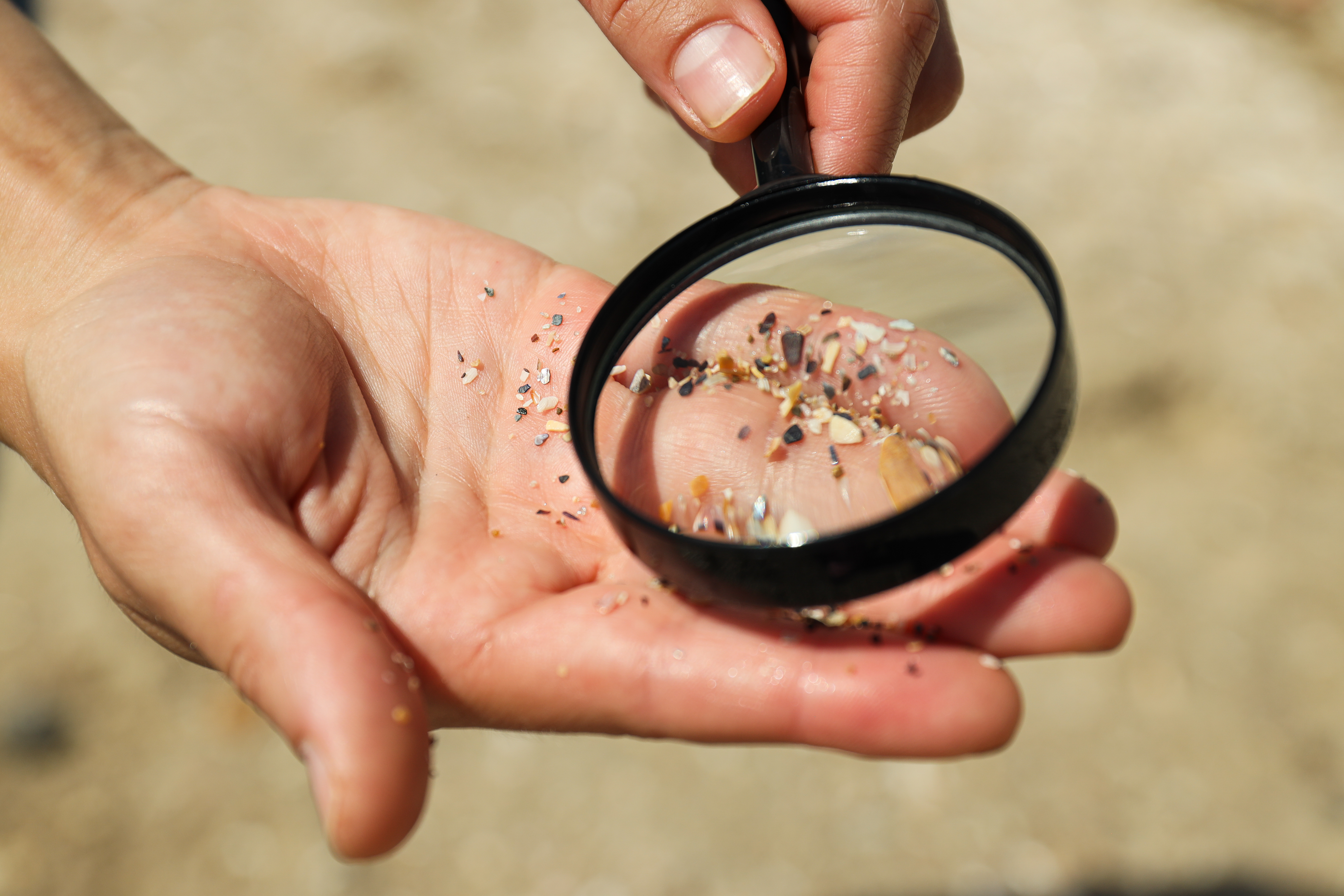Sand on the hands under a magnifying glass