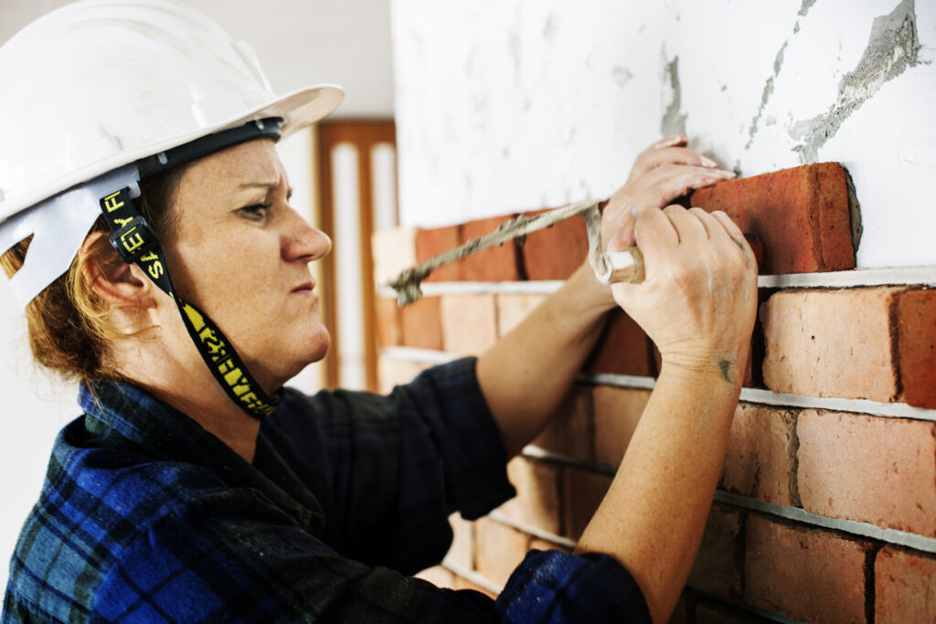 Woman construction repair plastering on the wall