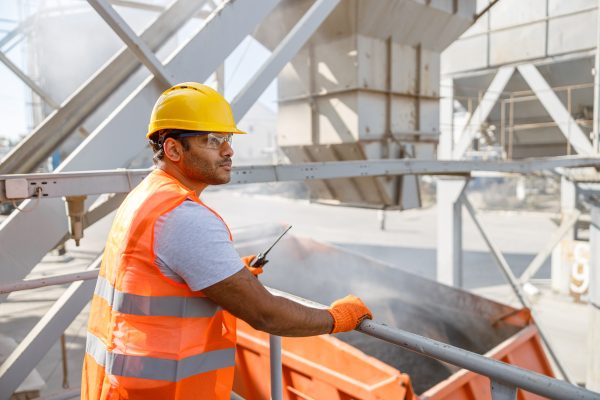 Industrial engineer, standing at construction site of concrete batching plant